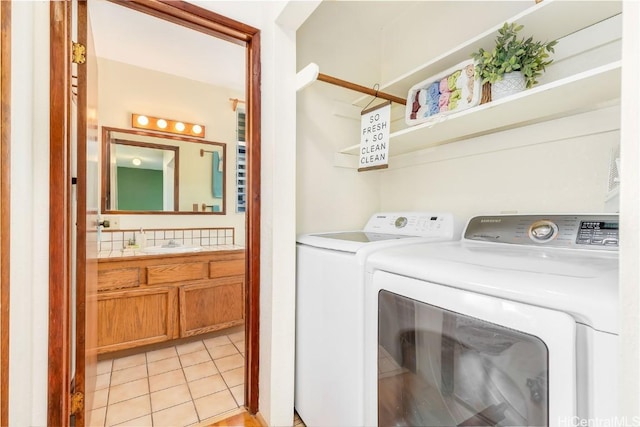 laundry room featuring light tile patterned floors, separate washer and dryer, and sink