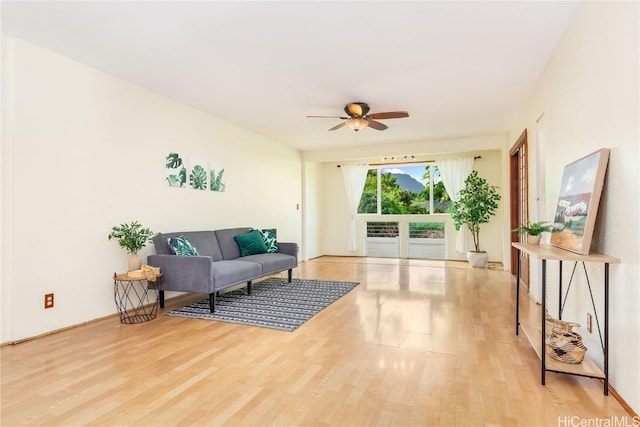 living room featuring ceiling fan and light hardwood / wood-style flooring