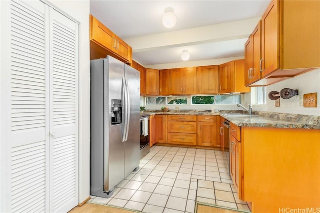 kitchen featuring light tile patterned flooring, stainless steel appliances, and sink