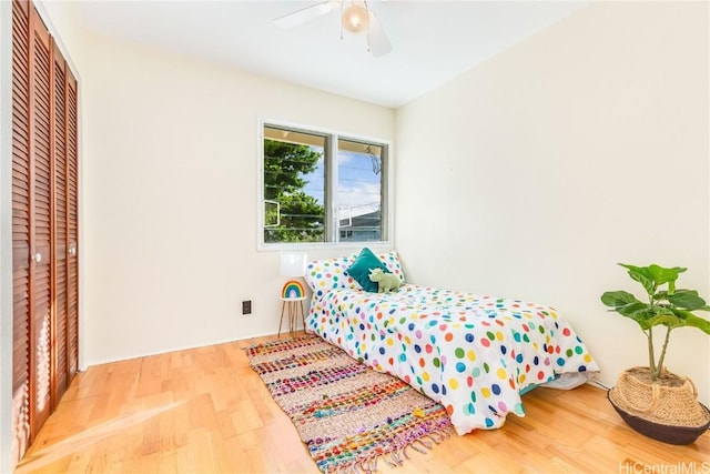 bedroom with ceiling fan, a closet, and wood-type flooring