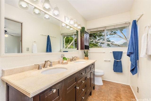 bathroom with tile patterned flooring, ceiling fan, toilet, and vanity