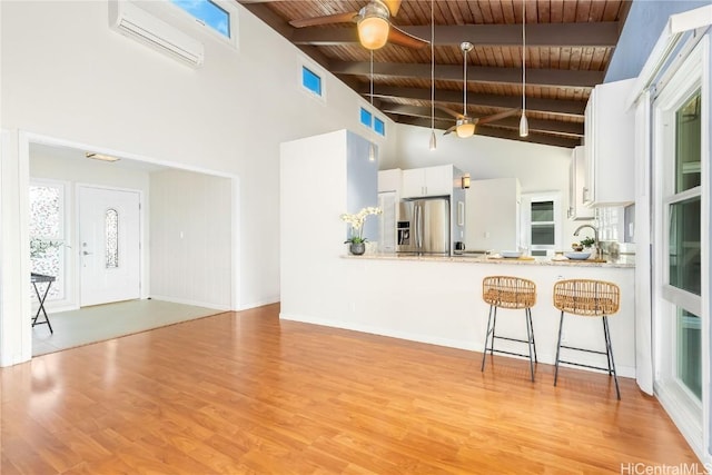 kitchen featuring wooden ceiling, kitchen peninsula, stainless steel fridge, white cabinets, and light wood-type flooring