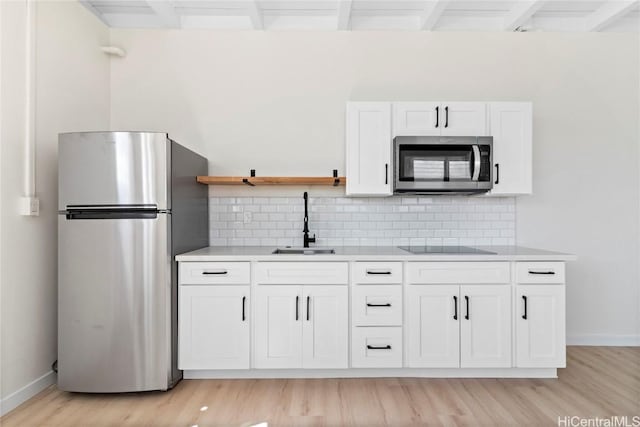 kitchen featuring open shelves, a sink, light countertops, white cabinets, and appliances with stainless steel finishes