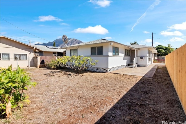 back of house with a fenced backyard and entry steps