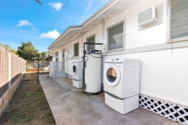 exterior space featuring gas water heater, a wall unit AC, separate washer and dryer, and fence