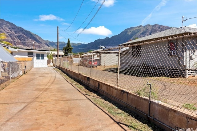 view of side of home with a mountain view and fence