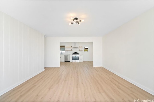 unfurnished living room featuring baseboards and light wood-type flooring