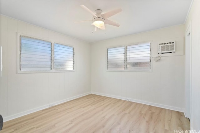 unfurnished room with a ceiling fan, an AC wall unit, wood finished floors, and baseboards