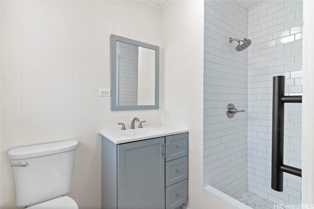 bathroom with vanity, toilet, and tiled shower