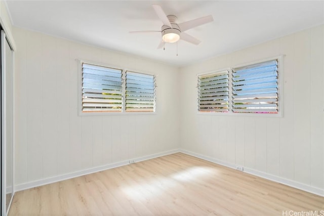 unfurnished room featuring baseboards, ceiling fan, and wood finished floors