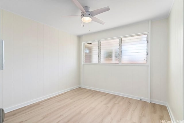 empty room with baseboards, a ceiling fan, and wood finished floors