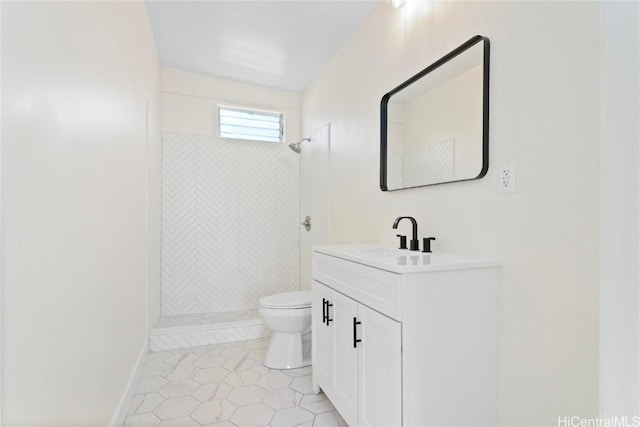 full bathroom with tile patterned floors, toilet, tiled shower, baseboards, and vanity