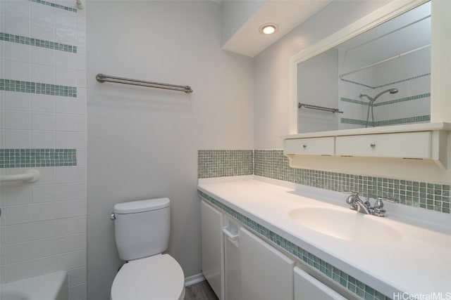 full bathroom featuring toilet, bathtub / shower combination, backsplash, and vanity