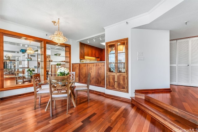 dining space featuring wood walls, wood-type flooring, and a textured ceiling