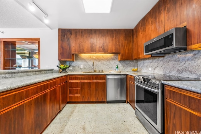 kitchen with light stone countertops, sink, backsplash, appliances with stainless steel finishes, and ornamental molding