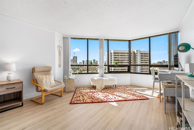 interior space with a textured ceiling, light wood-type flooring, and floor to ceiling windows