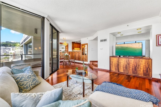 living room with crown molding, wood-type flooring, and a textured ceiling