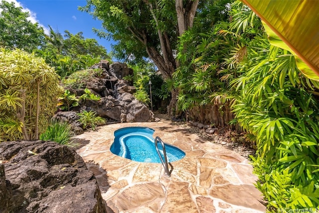 view of swimming pool featuring a patio area and a hot tub