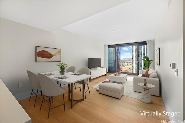 dining area with expansive windows and light wood-type flooring