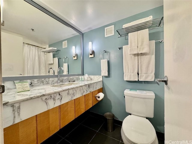 bathroom with tile patterned flooring, vanity, and toilet