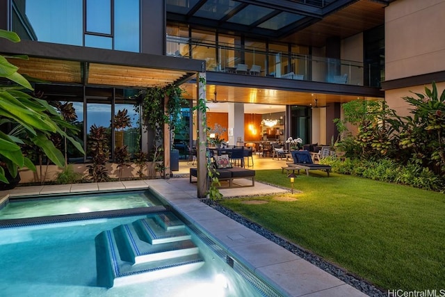 view of pool featuring a lawn, a patio area, and an in ground hot tub