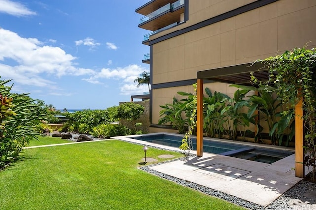 view of yard with a swimming pool with hot tub and a patio area