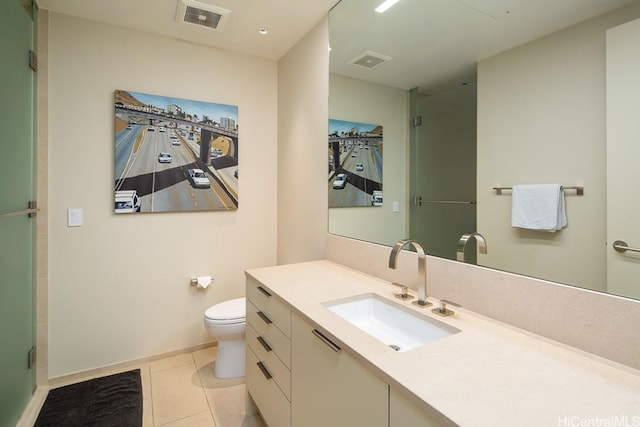 bathroom featuring tile patterned flooring, vanity, toilet, and walk in shower