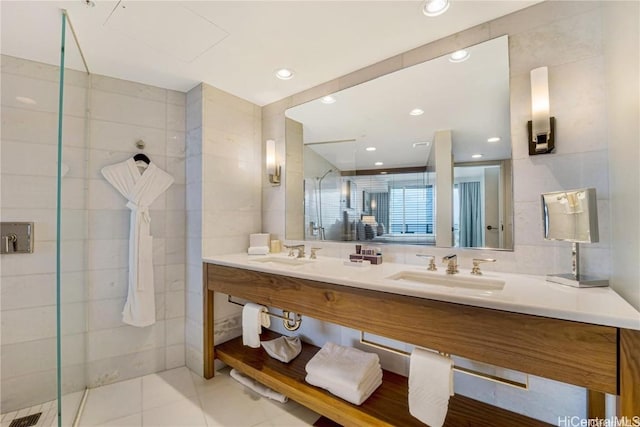 bathroom featuring tile patterned flooring, vanity, tile walls, and walk in shower