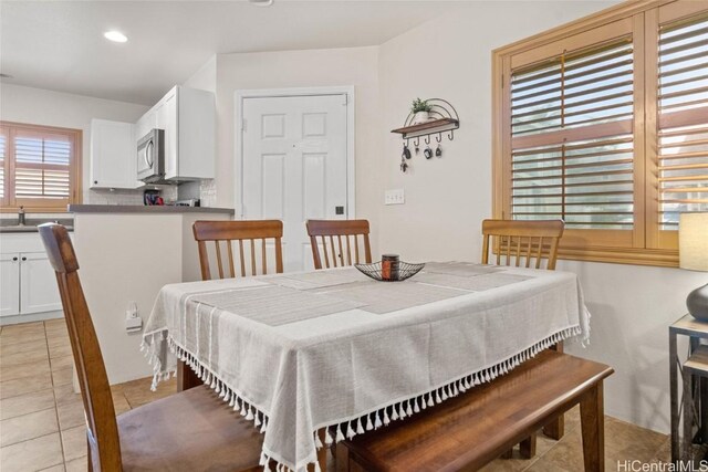 tiled dining room featuring sink