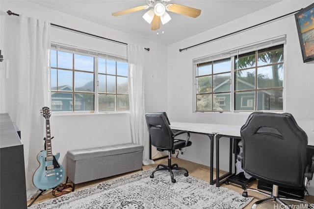 home office with ceiling fan and light hardwood / wood-style flooring