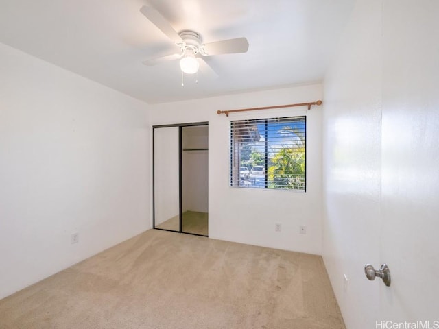 unfurnished bedroom with a closet, ceiling fan, and light colored carpet