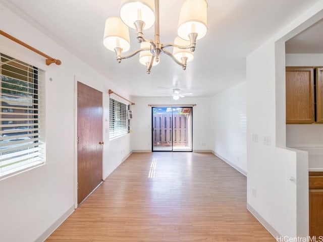 unfurnished dining area featuring light hardwood / wood-style flooring and ceiling fan with notable chandelier