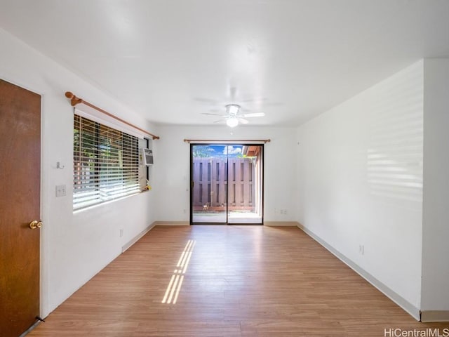 empty room with ceiling fan, light hardwood / wood-style floors, and a wall mounted air conditioner