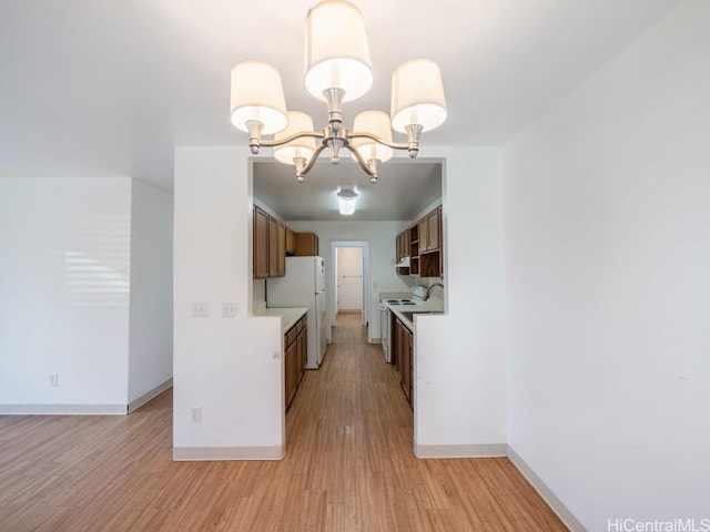 kitchen featuring white refrigerator, light hardwood / wood-style flooring, and a notable chandelier