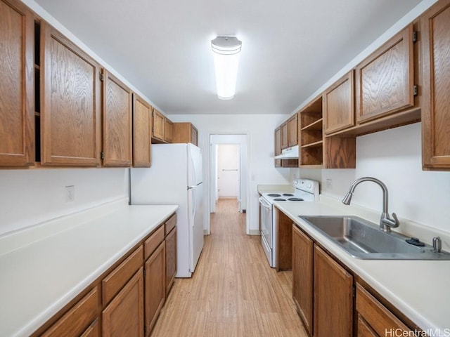 kitchen with sink, white appliances, and light wood-type flooring