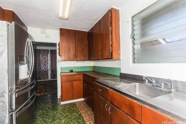 kitchen with stainless steel fridge, sink, and tasteful backsplash