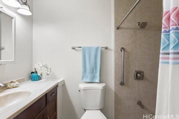 bathroom featuring toilet, vanity, and a shower with shower curtain