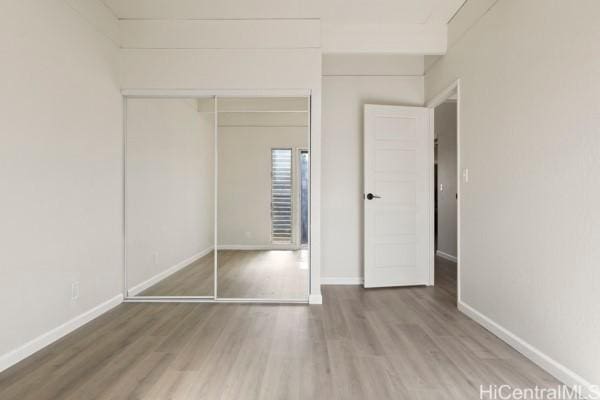 unfurnished bedroom featuring hardwood / wood-style flooring and a closet