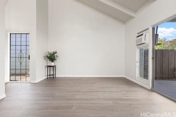 empty room with beamed ceiling, high vaulted ceiling, and hardwood / wood-style flooring