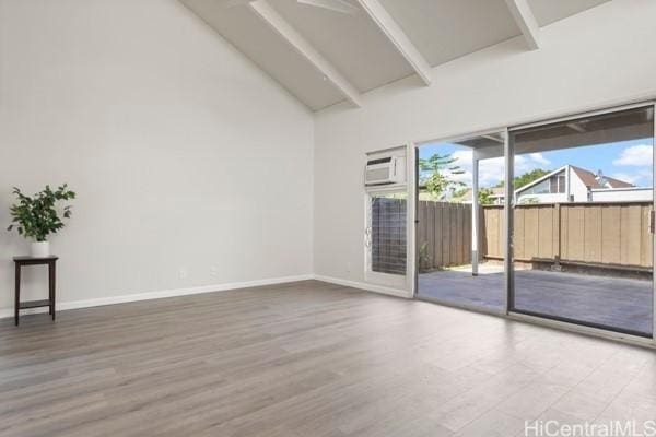 spare room with hardwood / wood-style floors and an AC wall unit