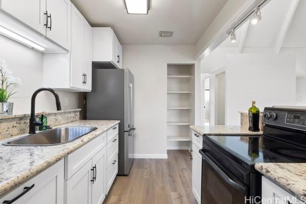 kitchen featuring beamed ceiling, white cabinetry, sink, and black electric range