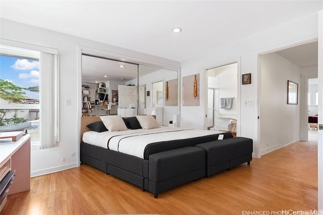 bedroom with light hardwood / wood-style floors, connected bathroom, and a closet