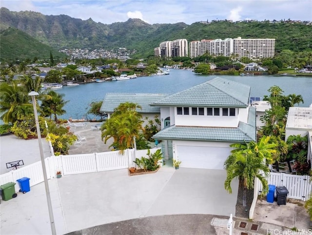 view of front of property with a garage and a water and mountain view