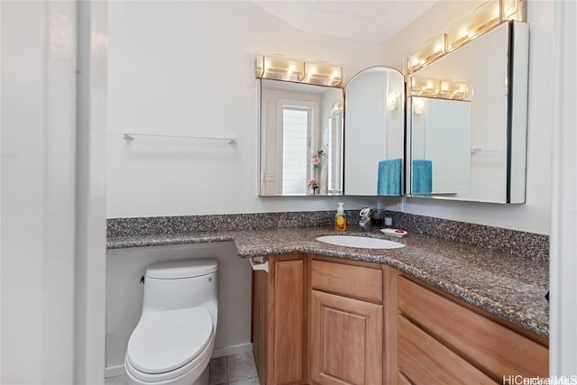 bathroom with tile patterned flooring, vanity, and toilet