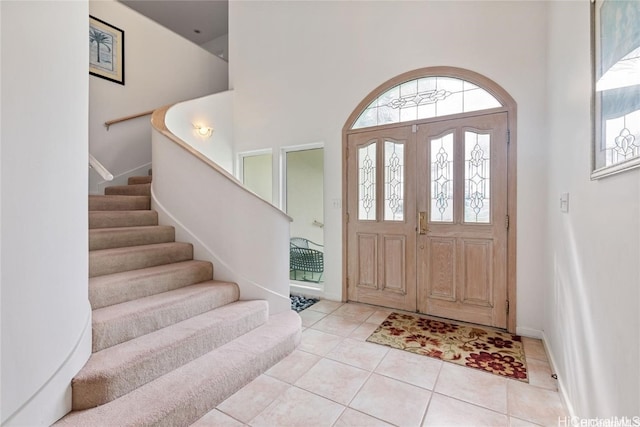 tiled entrance foyer featuring a high ceiling