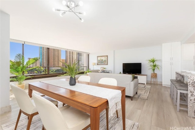 dining area with a notable chandelier and light hardwood / wood-style floors