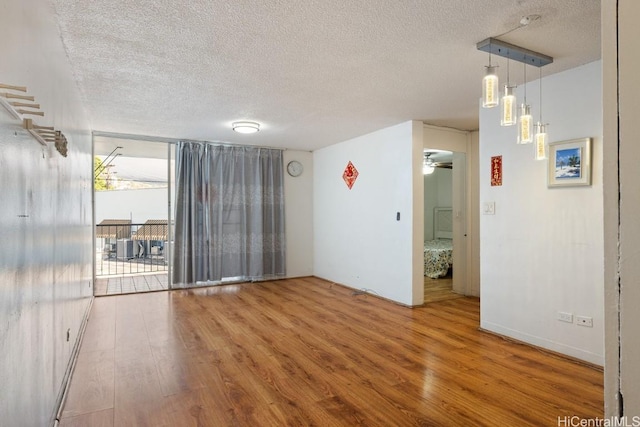 spare room with hardwood / wood-style floors, a textured ceiling, and ceiling fan