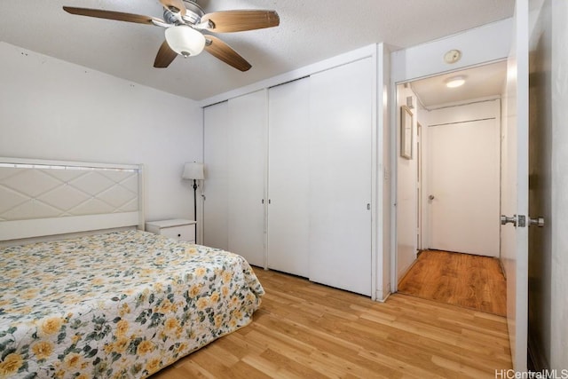 bedroom featuring a textured ceiling, light hardwood / wood-style floors, and ceiling fan