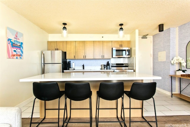 kitchen featuring a large island, light tile patterned floors, stainless steel appliances, and a textured ceiling