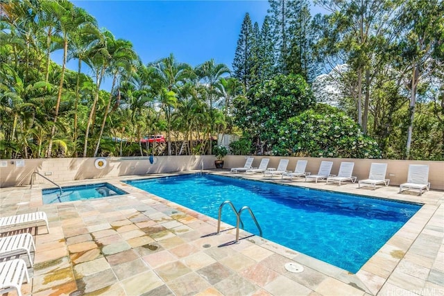 view of swimming pool featuring a patio area and a hot tub